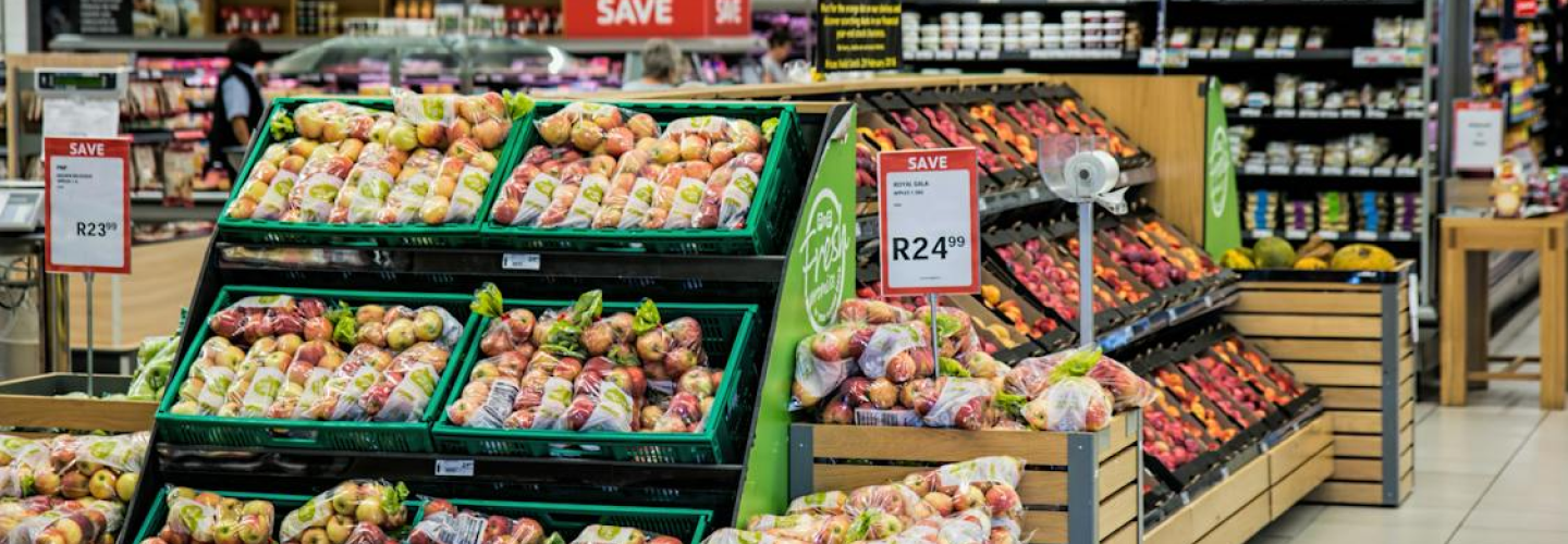 Supermarket produce section displaying various apples and price signs