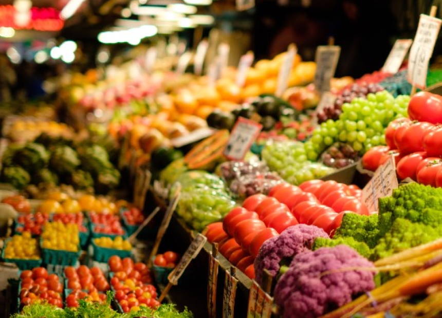 a row of colorful fruits and vegetables in a grocery store