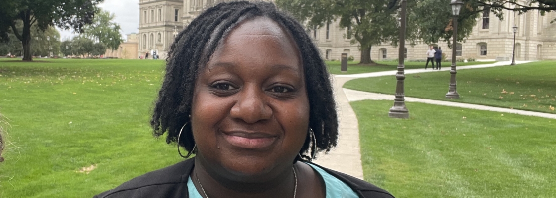 a woman standing in front of the Michigan capital building