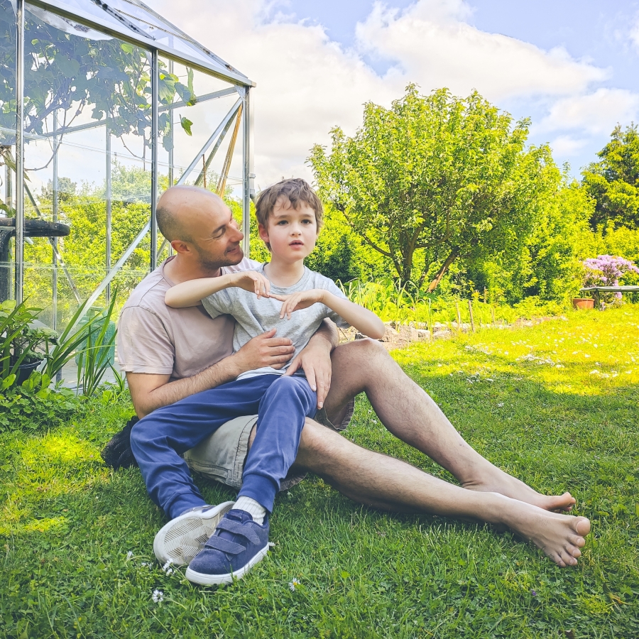 father sitting in garden and enjoying a connection together with his disabled son