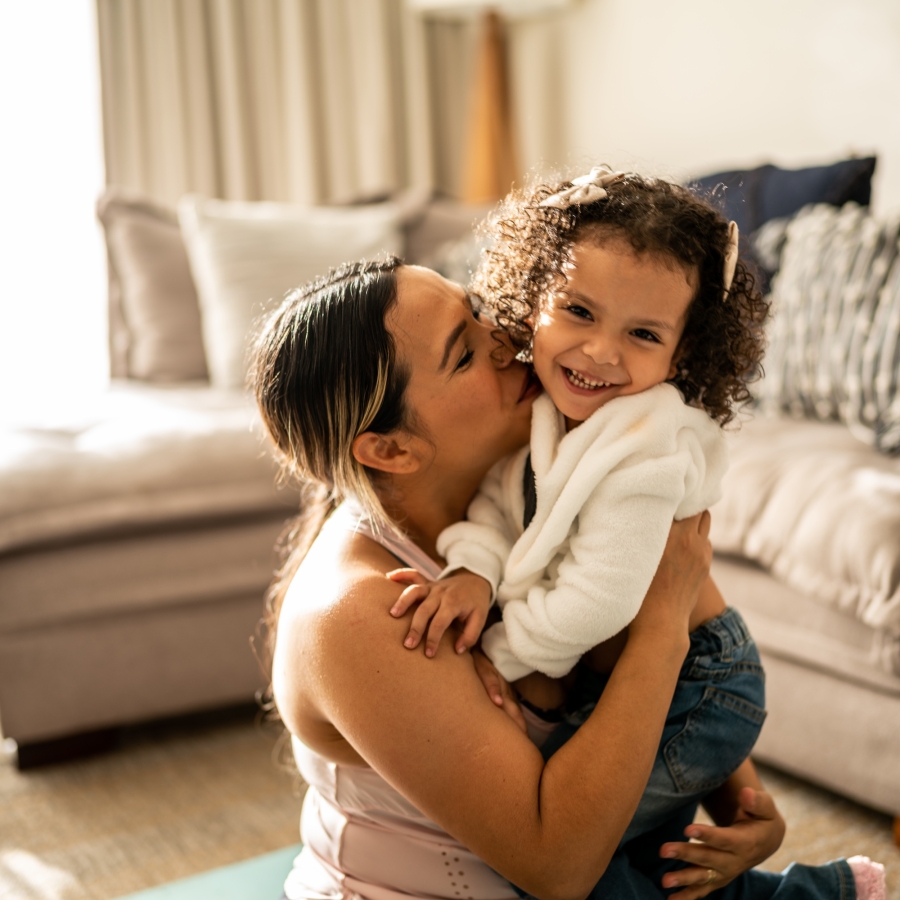 toddler girl having fun with her mother in the living room at home