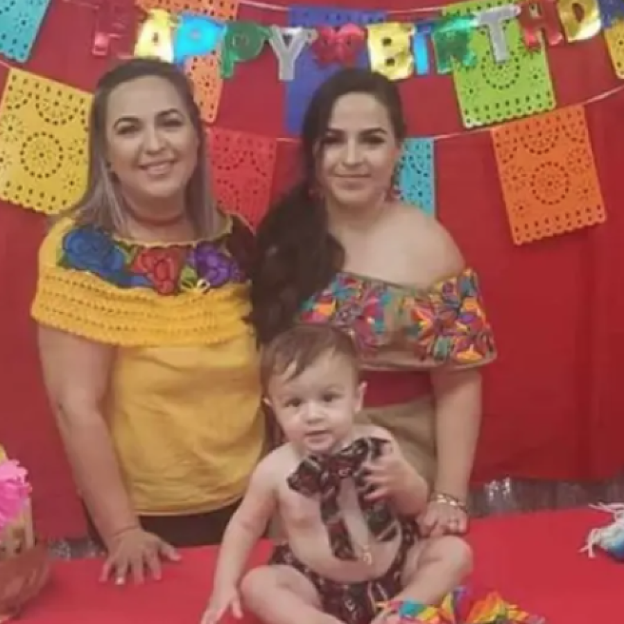 The Villa family poses for a photo in front of a festive red background